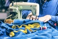 Sewing denim jeans with sewing machine. Repair jeans by sewing machine. Alteration jeans, hemming a pair of jeans, handmade Royalty Free Stock Photo