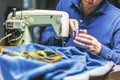 Sewing denim jeans with sewing machine. Repair jeans by sewing machine. Alteration jeans, hemming a pair of jeans, handmade Royalty Free Stock Photo