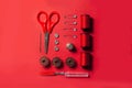 Sewing kit accessories and tools for needle work in red. Tape measure, pins, scissors, buttons, prewound bobbins, thimble, thread