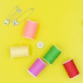 Sewing kit: thread, needles, measuring tape, buttons in a shopping cart on a yellow background. Royalty Free Stock Photo