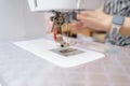 Sewing machine in action with skilled hands creating intricate fabric patterns during a crafting session at home Royalty Free Stock Photo