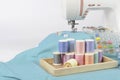 Sewing machine and colorful thread rolls, scissors, fabric and a Royalty Free Stock Photo