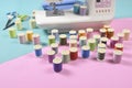 Sewing machine and colorful thread rolls for sewing on two tone Royalty Free Stock Photo