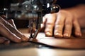 A sewing machine foot with the hands of a master close-up, a tailor makes a seam on a piece of leather on a sewing Royalty Free Stock Photo