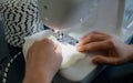 Sewing machine, hands preparing a white mask. By yourself to protect against viruses Covid-19