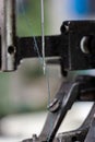 Sewing machine needle with blue thread macro close up shot on the test bench Royalty Free Stock Photo