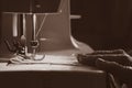 Sewing machine and old grandmother`s hand in a dark room sew