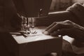 Sewing machine and old grandmother`s hand in a dark room sew