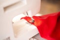 Sewing machine with red cloth closeup. sewing process in the re-stitching phase