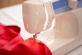 Sewing machine with red cloth closeup. sewing process in the re-stitching phase Royalty Free Stock Photo