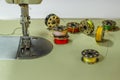 Sewing machine, on the table of which lie bobbins with multi-colored threads Royalty Free Stock Photo