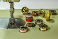 Sewing machine, on the table of which lie bobbins with multi-colored threads Royalty Free Stock Photo