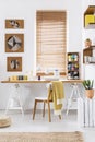 Sewing machine on a wooden desk by the window in a scandi crafts room interior with white walls and yarn. Real photo. Royalty Free Stock Photo