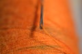 sewing needle on orange bobbin thread Royalty Free Stock Photo