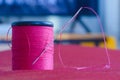 Sewing needle and pink thread roll