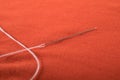 Sewing needle with white thread attached to it