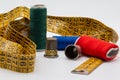 Sewing objects. Thimbles, colored threads, meter tape on wooden background.