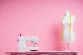 Sewing pattern,sewing machine and maniken in studio pink background.seamstress curve template. tailor creates a