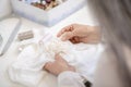 Female hands sewing white textiles at table