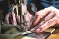 Sewing process of the leather belt. old Man`s hands behind sewing. Leather workshop. textile vintage sewing industrial