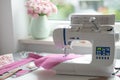 Sewing room with sewing machine, fabric, flowers and wom Royalty Free Stock Photo
