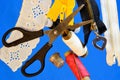 Sewing - a set of threads, vintage scissors, needles, thimble, on a creative blue background. A set of threads on the coils,