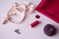 Sewing still life: centimeter tape, fabric, thread, needle, button on a pink background Royalty Free Stock Photo