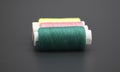 Sewing thread and bobbin in DarkCyan on isolated black background