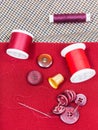Sewing thread, buttons, thimble on red cloth Royalty Free Stock Photo