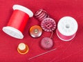 Sewing thread, buttons, thimble on red tissue Royalty Free Stock Photo