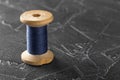 Sewing thread on an old wooden spool with dark concrete background Royalty Free Stock Photo