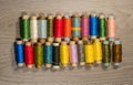 Sewing thread reels on a wood textured background.