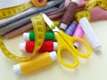 Sewing thread spools, measuring tape, colorful textile  and scissors. Sewing supplies, and accessories for needlework, stitching, Royalty Free Stock Photo