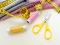 Sewing thread spools, measuring tape, colorful textile  and scissors. Sewing supplies, and accessories for needlework, stitching Royalty Free Stock Photo