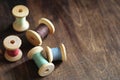 Sewing thread on a wooden background. Set of threads on bobbins retro style. Vintage accessories for sewing on the table Royalty Free Stock Photo