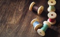 Sewing thread on a wooden background. Set of threads on bobbins retro style. Vintage accessories for sewing on the table Royalty Free Stock Photo