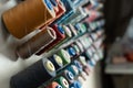Sewing threads of different colors are installed on a metal wall and are in the sewing workshop  side view. Manufacturing and Royalty Free Stock Photo