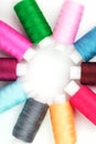 Sewing threads of different colors on reels on a white background in a circle Royalty Free Stock Photo