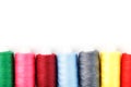 Sewing threads of different colors on reels on a white background. Free space, close-up. Isolate Royalty Free Stock Photo