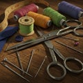 Sewing tools arranged on a wooden surface, featuring brightly colored spools of Royalty Free Stock Photo
