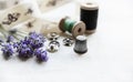 Sewing tools with fresh lavander flowers on linen background. Vintage wooden spool, braid, thimble, buttons. Royalty Free Stock Photo