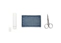 Sewing tools including thread spool, scissors, and threader laid out on a white background Royalty Free Stock Photo