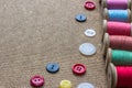 Sewing tools many different colorful thread, many different buttons on wooden background.