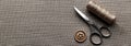 Sewing Tools: Scissors, Thread Spool, and Button on Rustic Fabric Texture Royalty Free Stock Photo