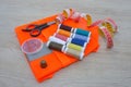 Sewing tools and sewing kit on wooden textured background. Thread, needles and cloth Royalty Free Stock Photo