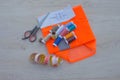 Sewing tools and sewing kit on wooden textured background. Thread, needles and cloth Royalty Free Stock Photo