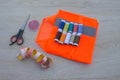 Sewing tools and sewing kit on wooden textured background. Thread, needles and cloth Royalty Free Stock Photo