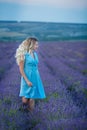 Sex appeal blond woman in airy blue dress enjoy life time vacation on fresh lavender field by walking or spinning around. Sylph