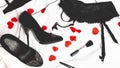 Sex concept. Black suspenders, Garter belt, shoes, female accessories on a white background of a bed with hearts. Valentines Day