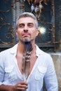 Sexi Man in a white shirt and ornamental window on background. And Dream Catcher and eagle feathers. Royalty Free Stock Photo